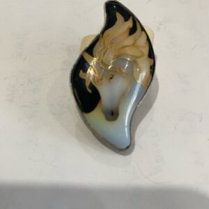 Broche de caballo en blanco y negro con detalles dorados, elegante y llamativo. Perfecto para cualquier atuendo.