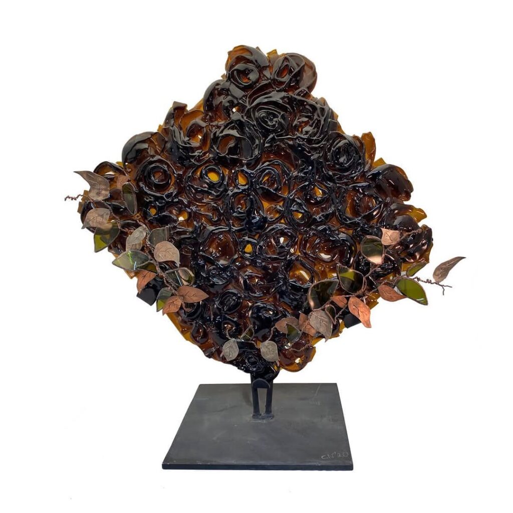 Escultura de una flor con hojas, mostrando detalles delicados y un diseño artístico en un material elegante.